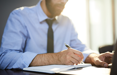 employee-with-pen-making-notes-in-notebook