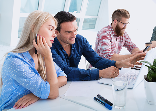 male-and-female-employees-looking-at-laptop