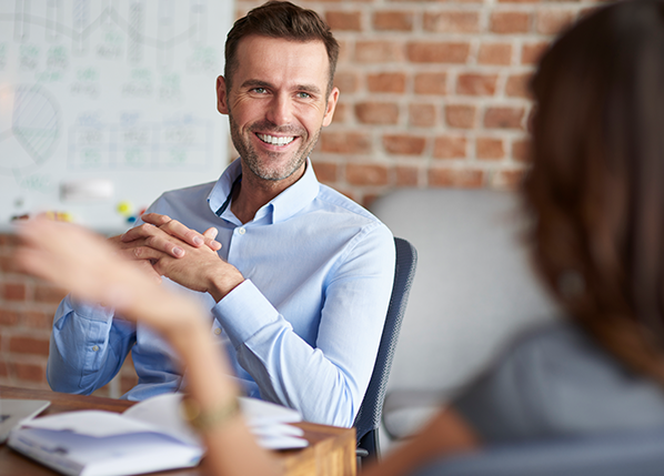 smiling-male-employee-sat-at-desk