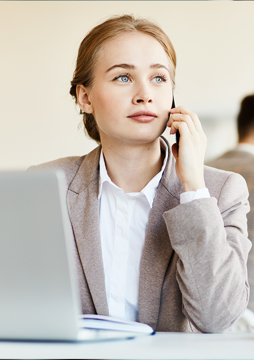 young-employee-with-smartphone-calling-by-workplace-in-office